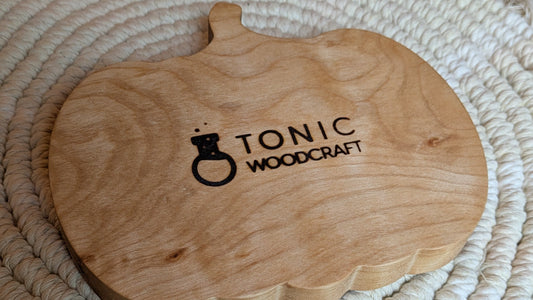 Wooden tray with 'Tonic Woodcraft' branding on a woven mat.